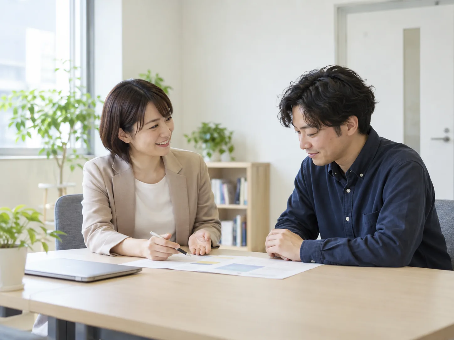 テーブルを囲み、作業の進め方を一緒に相談する二人
